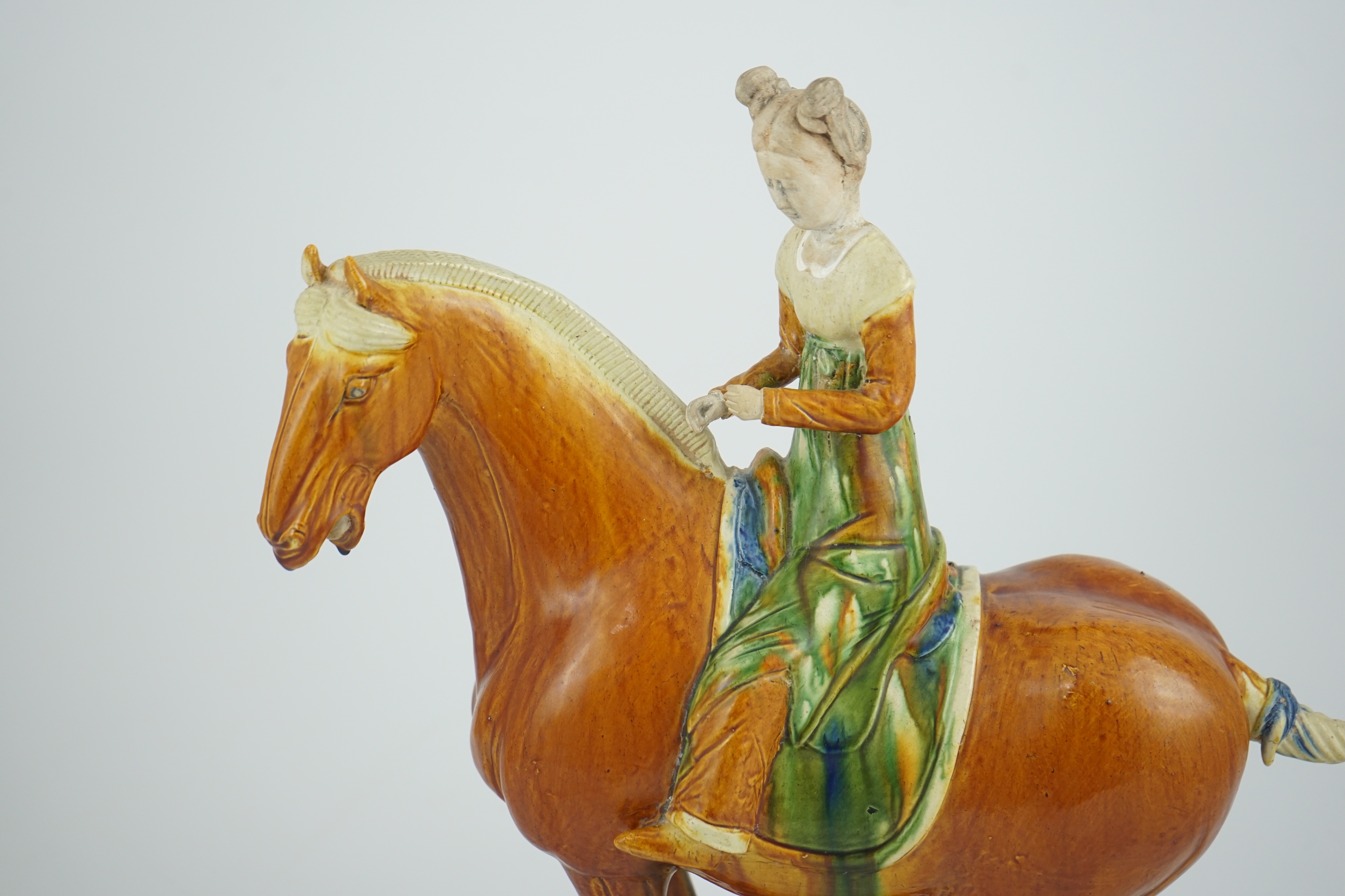 A Chinese sancai glazed group of a horse and female rider, Tang or later